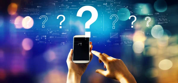 Question marks with person using a smartphone