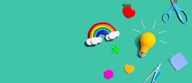 Idea light bulb with a rainbow and school supplies overhead view - flat lay