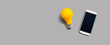 Yukarıdan sarı ampullü akıllı telefon.