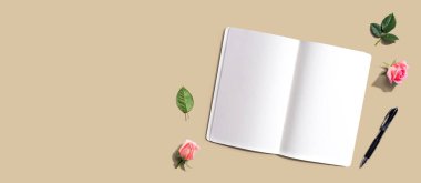 Gül bütçeli bir kalemle defter ya da günlüğü aç - düz yatı-