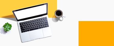 Yukarıdan kahve fincanı olan bir dizüstü bilgisayar.