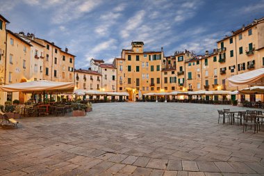 Lucca, Tuscany, İtalya: Eski ortaçağ şehrinde açık hava barları ve restoranları olan antik eliptik amfitiyatro meydanı (Piazza dell 'anfiteatro)
