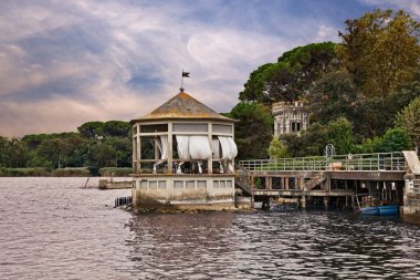 Torre del Lago Puccini, Viareggio, Lucca, Toskana, İtalya: Bir taraçalı Massaciuccoli Gölü manzarası ve çam ormanlarındaki antik bir villanın kulesi