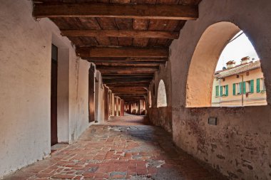Brisighella, Ravenna, Emilia Romagna, Italy, the donkeys alley - medieval walkway perched above street level with a long line of arched openings facing the street