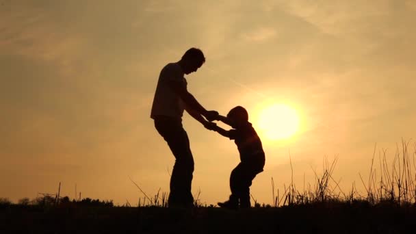 Niño sube en su padre silueta — Vídeo de stock