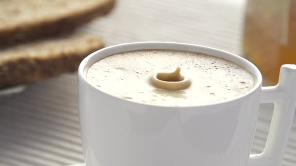 Caída de leche en cámara lenta salpicaduras en el café — Vídeo de stock