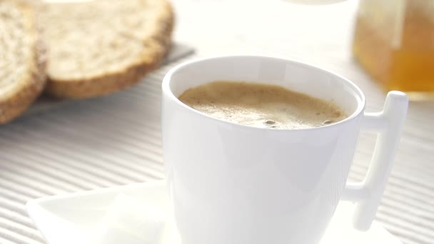 Caída de leche en cámara lenta salpicaduras en el café — Vídeo de stock