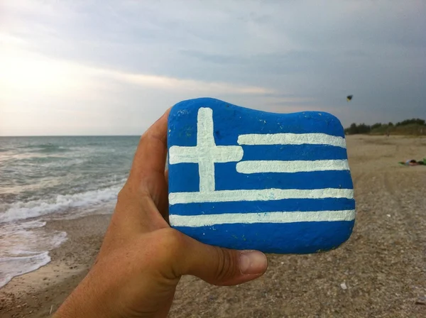 Флаг Греции на камне с пляжным фоне — стоковое фото