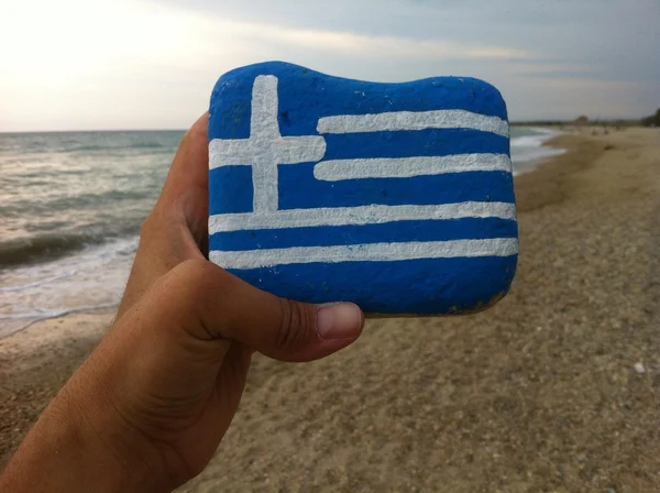 Bendera Yunani pada batu dengan latar belakang pantai — Stok Foto