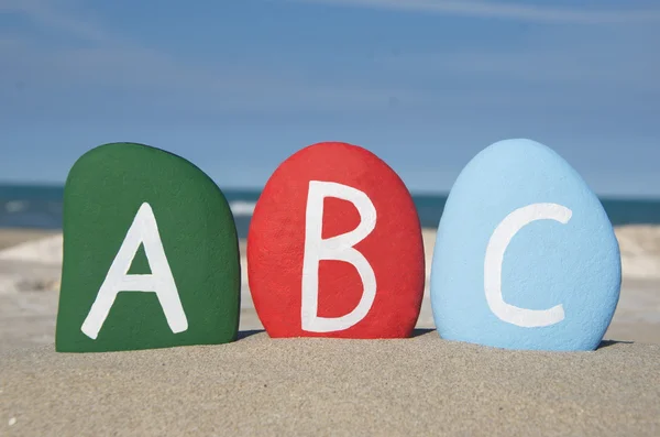 ABC op stenen, letters op het zand — Stockfoto