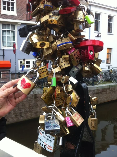 Cadeados amor em cadeias na área central de Amsterdã, Países Baixos — Fotografia de Stock