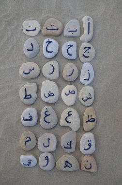 Taşların üzerinde kum üzerinde Arap alfabesi