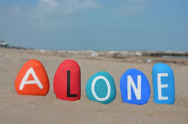 Kum üzerine renkli taş harfler üzerinde yalnız kavramı — Stok fotoğraf