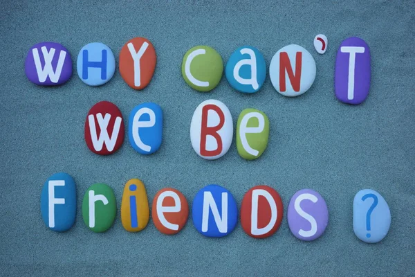 Why can\'t we be friends, creative question composed with multi colored stone letters over green sand