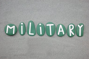 Yeşil kumların üzerine yeşil boyalı taş harflerle yazılmış askeri bir kelime.