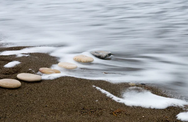 Piedras de playa lisas en un crudo —  Fotos de Stock