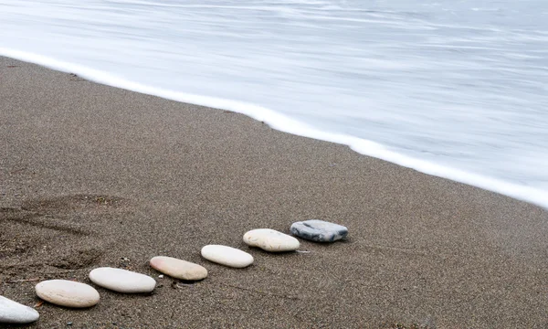 Piedras de playa lisas en un crudo — Foto de Stock