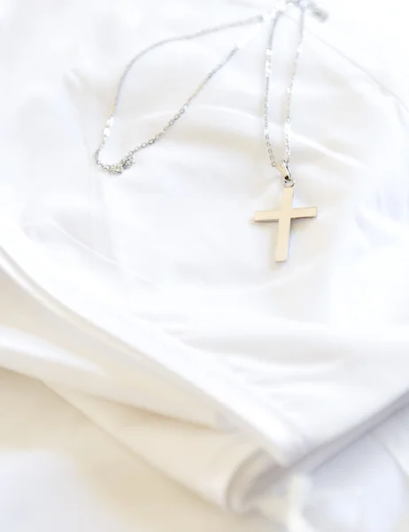 Silver cross on white cloth. — Stock Photo, Image