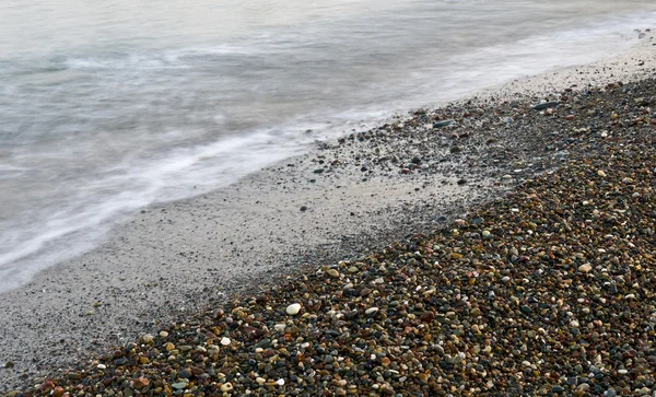 Zee golven en pebblesbackground — Stockfoto