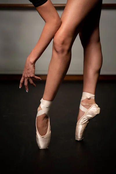 Nohy mladé baletky se špičatými botami tančícími na černé podlaze. Baletní trénink. nohy baletky. — Stock fotografie