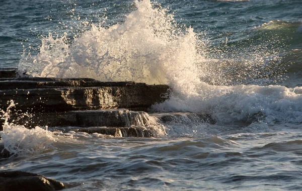 Fırtınalı rüzgarlı deniz dalgaları kayalık bir sahile vuruyor. — Stok fotoğraf