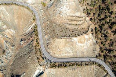 Hava aracı manzaralı dağ manzarası boş eğimli bir yol..