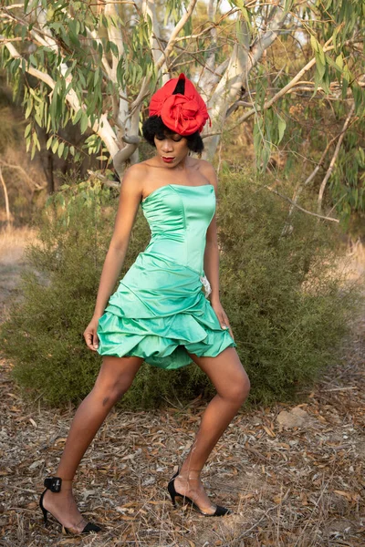 Stylish african woman with and green sexy clothing doing modeling in the park — Stock Photo, Image