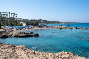 Turkuaz suyu olan plaj ve yaz tatillerinde yüzen turistlerle dolu..