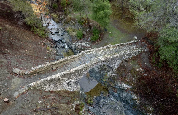 Drone aerial view of a medieval stoned bridge water flowing in the river in autumn. — Stock Photo, Image