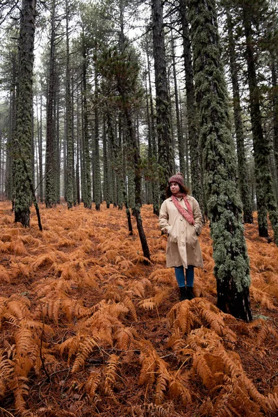 Młoda kobieta w odzieży robaka stojąca zimą w lesie. — Zdjęcie stockowe