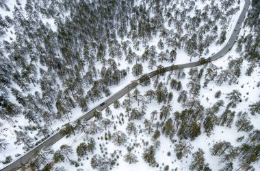 Kışın karlı dağı geçen asfalt bir otoyolun insansız hava aracı fotoğrafı..