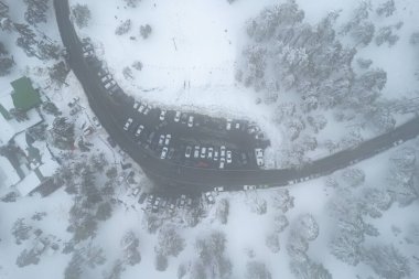Kışın, karlı orman dağının tepesinde bir arabanın insansız hava aracı parkı. Kış mevsimi