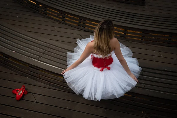 Bailarina vestida con vestido rojo blanco navideño posando en el suelo — Foto de Stock