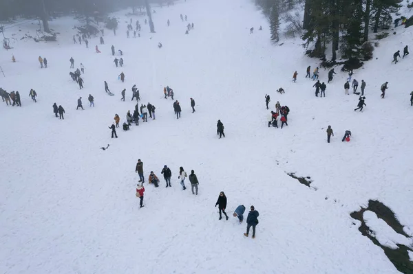 Drone aerial scene with people playing at snow in winter. Wintertime games. — Stockfoto