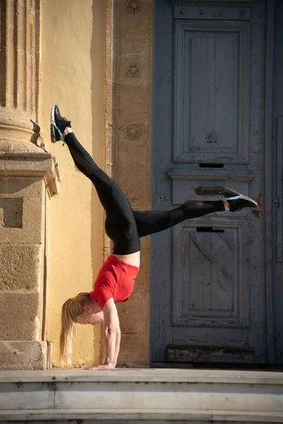 Спортивна жінка в спортивному одязі виконує вправи з рівноваги. Фітнес дівчина в легінсах на відкритому повітрі — стокове фото