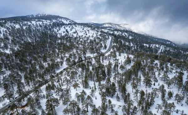 Drone flygfoto av en asfalt motorväg som korsar det snöiga berget på vintern. — Stockfoto