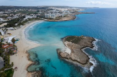 Kışın boş kumsalın sahil şeridine insansız hava aracı görüntüsü. Yaz tatili. Nissi plajı Ayia Napa, Kıbrıs