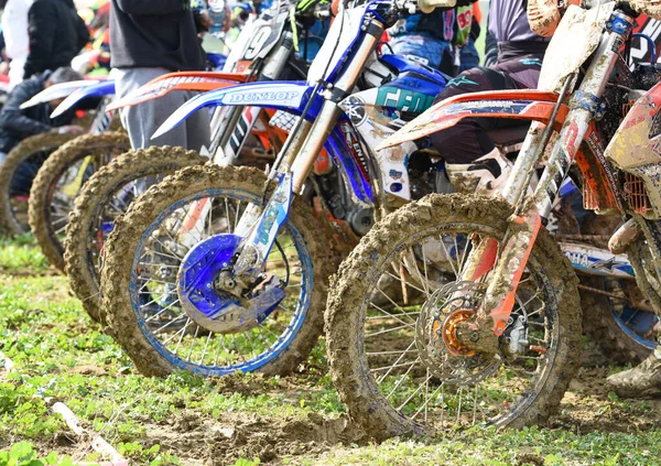 Atleti non riconosciuti che guidano una moto sportiva e una ruota fangosa su un evento di corse di motocross — Foto Stock