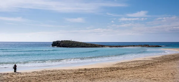 Una persona parada en una playa tropical vacía con arena dorada en invierno — Foto de Stock