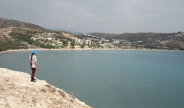 Ung kvinna står vid kanten av en klippa och njuter av havslandskapet. Pissouri kustlinje Limassol Cypern — Stockfoto