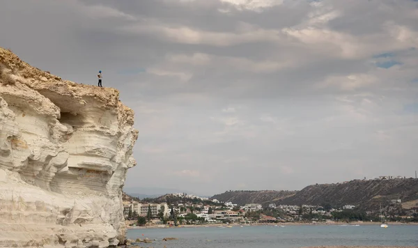 Uçurumun kenarında oturan genç bir kadın deniz manzarasının tadını çıkarıyor. Pissouri kıyı şeridi Limasol Kıbrıs — Stok fotoğraf