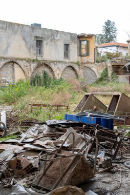 Çöken binanın terk edilmiş dış yüzeyi. Yerde atıklar var. Çevre kirliliği terk edilmiş yerler
