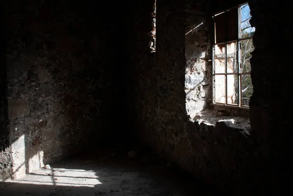 Terk edilmiş eski boş odanın içi. Kırık camlar parlak güneş ışığı yerde parlıyor. — Stok fotoğraf