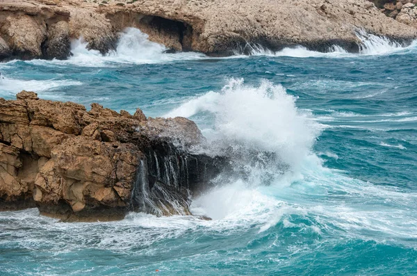 Ondas ventosas tempestuosas batendo nas rochas em uma costa rochosa — Fotografia de Stock