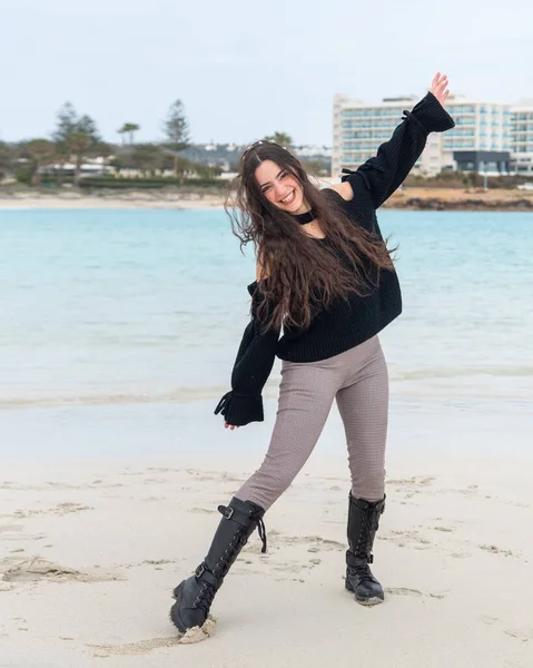 Счастливая молодая женщина в случайном стиле смеется над песчаным пляжем. Отдых, веселье и отдых. — стоковое фото