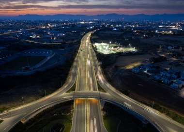 Otoyol kavşağının hava aracı görüntüsü. Dolambaçlı arabalar hızlı hareket ediyor. Ulaşım altyapısı