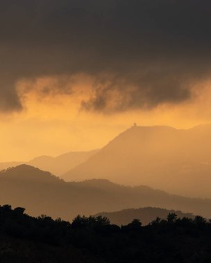 Sunset with stormy cloud sky and dramatic orange sunlight above mountain Troodos mountains Cyprus