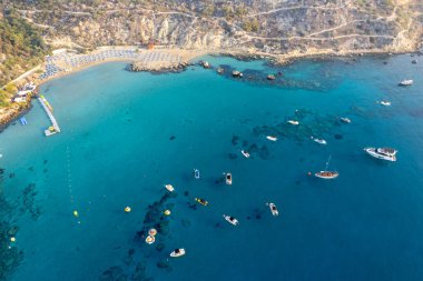 Drone aerial seascape with luxury yachts moored on the coast and unrecognised people swimming and relaxing. Summer vacations in the sea. Konnos bay Ayia Napa Cyprus