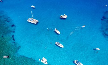 Drone aerial seascape with luxury yachts moored on the coast and unrecognised people swimming and relaxing. Summer vacations in the sea. Ayia Napa Cyprus