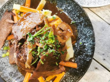 Pişmiş domuz bifteği ve sağlıklı sebzelerle enfes tabaklar. En üste sos garnitürü. Geleneksel mutfak